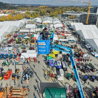 Blick von oben auf das Außengelände der Oberschwabenschau in Ravensburg: Es sind viele landwirtschaftliche Fahrzeuge ausgestellt. 