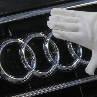 Hand streicht über Logo des Autobauers Audi.