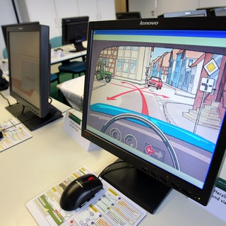Auf Bildschirmen ist in einem Prüfungszimmer eine Prüfungsfrage zu sehen (Symbolbild). Eine Fahrschule in Heilbronn hat im großen Stil bei der Theorieprüfung betrogen. Das Netzwerk flog jetzt auf.