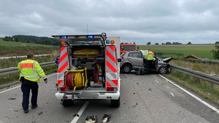 Ein Polizist steht an einem der verunfallten Autos: Ein Mensch starb bei den Unfall auf der B19, mehrere wurden schwer verletzt