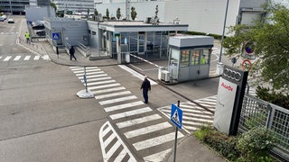 Tor 6 am Audi-Standort Neckarsulm. Mitarbeiterinnen und Mitarbeiter fragen sich, welche Rolle ihr Standort im Wandel von Verbrennungsmotoren zur Elektromobilität in Zukunft spielen wird.