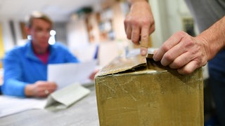 Ein Paket wird beim Zoll geöffnet. Bei Online-Shopping im Nicht-EU-Ausland fallen schnell zusätzliche Kosten an - der Zoll warnt.