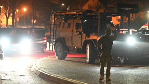Ein Spezialfahrzeug der Polizei und Einsatzkräfte stehen bei einem Polizeieinsatz in Sulzbach-Laufen (Landkreis Schwäbisch Hall) bereit. Die Polizei unterstützte dort das Jugendamt bei einer Inobhutnahme.
