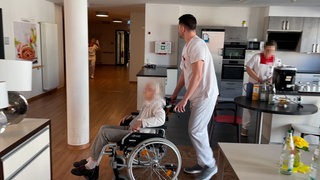 Die Bewohnerin eines Pflegeheims wird im Rollstuhl geschoben. Auch Menschen mit Demenz dürfen bei der Landtagswahl in Baden-Württemberg wählen.