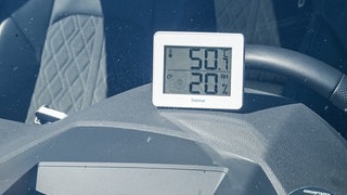Ein Digitalthermometer zeigt die Temperatur im Innenraum eines Autos an (Symbolbild). 