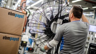 Ein Mitarbeiter des Elektromotoren- und Ventilatorenherstellers ebm-papst, arbeitet in der Produktion an einem Ventilator