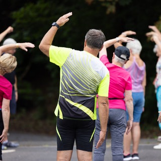 Menschen von hinten bei Dehnübungen
