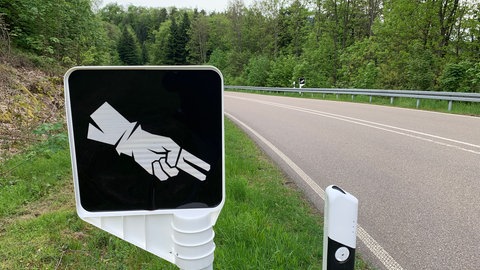 Entlang des Schweigekilometers ist der "Bikergruß" auf vielen Schildern präsent