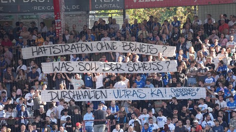 Die Hoffenheimer Nach Einsatz von Pyrotechnik: Hoffenheimer Fans zeigen sich beim Spiel in Berlin solidarisch mit den verurteilten KSC-Anhängern.