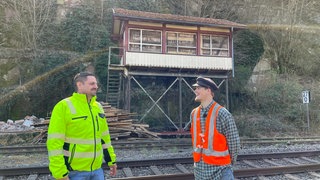 Matthias Langen (rechts) von den Eisenbahnfreunden will das historische Stellwerk 2 am Bahnhof Calw retten. Noch wird es von Mitarbeitern einer Sicherheitsfirma (links) bewacht.