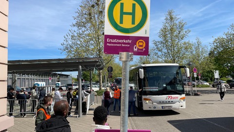 Reisende am Bahnhof in Baden-Baden stehen Schlange, um mit dem Schienenersatzverkehr weiterzufahren. 
