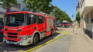 Feuerwehreinsatz an Fronleichnam in der Karlsruher Weststadt. Feuerwehrauto in Straße. Feuer auf Balkon greift auf Wohnung über.
