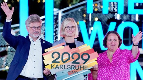 Karlsruhes Oberbürgermeister Dr. Frank Mentrup, Dr. Christiane Schenderlein (Mitte), Staatsministerin für Sport und Ehrenamt und Theresa Schopper, Sportministerin Baden-Württemberg, bei der Flaggenübergabe bei den World Games in Chengdu.