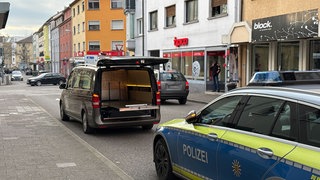 Ein Leichenwagen steht auf der Straße vor einem Polizeiauto. Die Staatsanwaltschaft hat die Ermittlungen gegen einen Polizisten eingestellt, der im Januar bei einem Einsatz in Bruchsal einen Mann erschossen hatte.