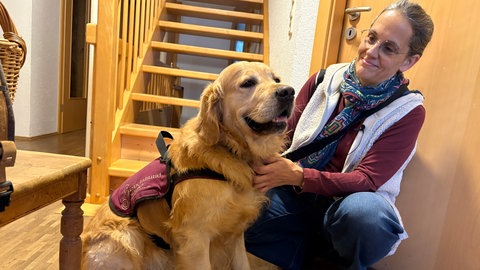 Palliativhund Hannes bekommt für seine Arbeit eine extra Weste angezogen.