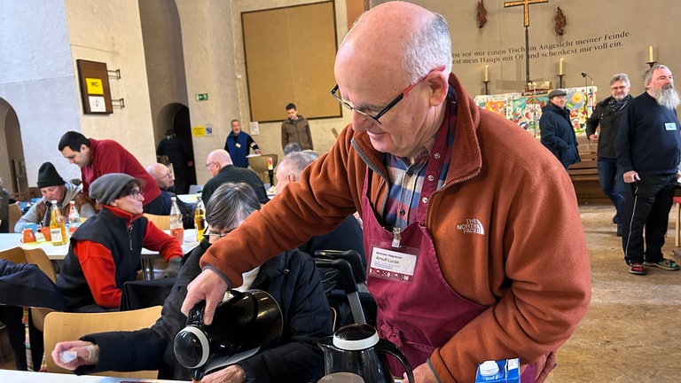 Arnulf Lucas schenkt Kaffee aus. Er hilft seit über zehn Jahren in der Vesperkirche in Karlsruhe.