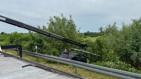 Unfall zwischen A5 und B10: Auto landet in der Böschung im Gestrüpp und muss mit Kran gehoben werden.