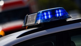 Das Blaulicht eines Einsatzfahrzeugs der Polizei leuchtet an einer Einsatzstelle.