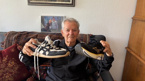 Der 93-jährige Läufer Arne Haase zeigt seine Schuhe.