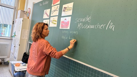 Kinder sitzen im Stuhlkreis in einer Schule. Tina Rastätter und ihre Kolleginnen zeigen Kindern an Schulen, wie sie sich in schwierigen Situationen richtig verhalten.