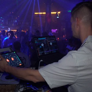 DJ Jan Rahmisch steht auf der Bühne und vor ihm die tanzende Menge im Saal 51