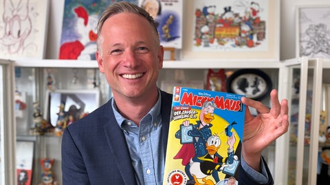 iPad-Magier Simon Pierro zeigt Titelbild des Micky Maus-Heftes