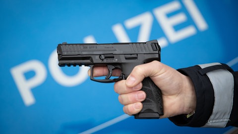 Polizist hält eine Dienstwaffe