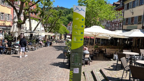 Ein Aufsteller in Weinheim (Rhein-Neckar-Kreis) auf dem Marktplatz in der Altstadt dirket vor dem alten Rathaus. Hier sieht man den Wegweiser und einen der QR-Codes, für die sogenannte "Mundart-Führung"
