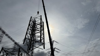 Ein Kran hebt einen alten Strommast auf der Ultranet-Baustelle an.