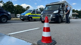 Ein Polizist kontrolliert ein Wohnmobil auf der A6 bei Hockenheim