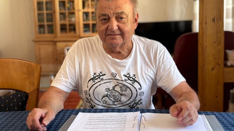 Karlheinz Falkenstein vor einem Aktenordner