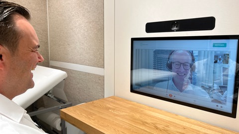 Telemedizinische Sprechstunde - eine Person spricht mit einer anderen Person auf dem Monitor