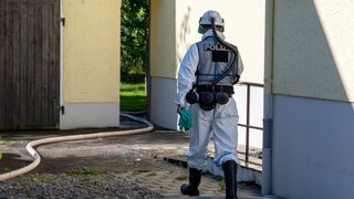 Ein Polizist der Brandermittlung geht in ein Haus (Symbolbild).