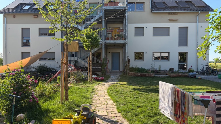 Der weiße Neubau hat drei Etagen. In jedem Stock gibt es eine gemeinschaftlich genutzte Terasse.