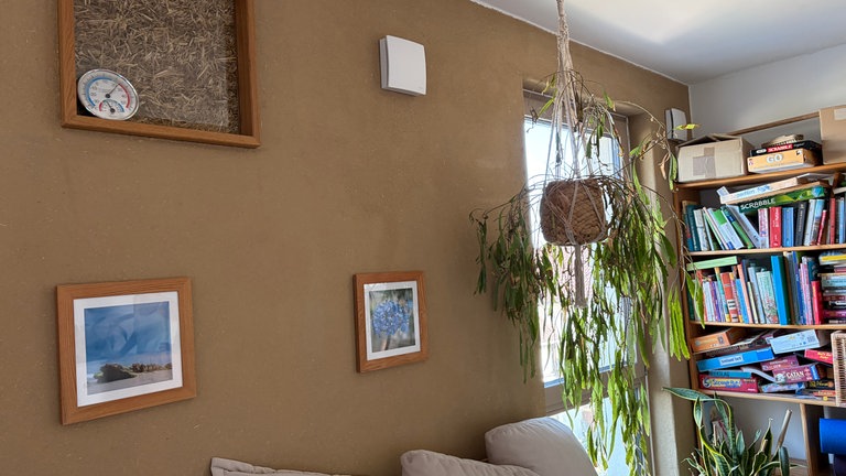 Das Haus wurde aus Holz, Lehm und Stroh gebaut. In einem Gemeinschaftswohnzimmer ist eine Glasscheibe eingelassen, durch die man die dahinterliegende Strohwand erkennen kann.