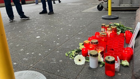 Am Bahnsteig liegen Blumen und stehen Grablichter im Gedenken an den getöteten Zugbegleiter 