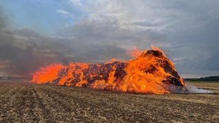 Strohballen brennen auf Feld in St. Leon-Rot