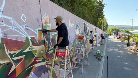 Ein Graffiti-Künstler sprüht ein Graffitikunstwerk.