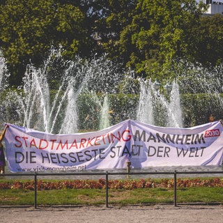 Klimaaktivisten mit Banner "Mannheim - Heißeste Stadt" vor dem Wasserturm