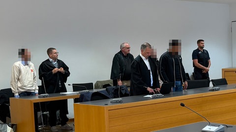 Die drei Angeklagten mit ihren Anwälten