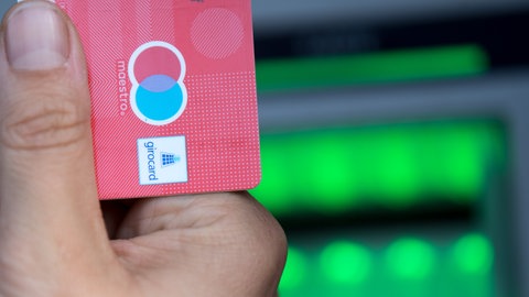 Eine Bankkarte wird hochgehalten.
