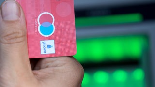 Eine Bankkarte wird hochgehalten.