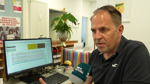 Kinderarzt Ralf Brügel aus Schorndorf sitzt in seiner Praxis und gibt ein Interview. Zusammen mit anderen Kinderärztinnen und -ärzten hat er im Rems-Murr-Kreis einen Protesttag organisiert.
