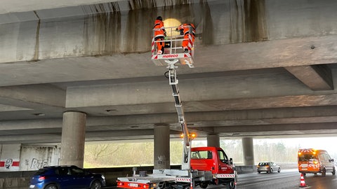 Mit Hilfe eines Hubsteigers wird an der Unterseite der A8-Brücke am Kreuz Stuttgart aktuell der Beton abgeklopft.