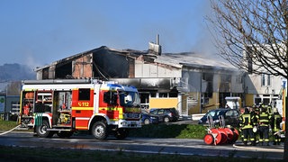Ein Feuerwehrfahrzeug steht vor dem abgebrannten Gebäude in Schorndorf 