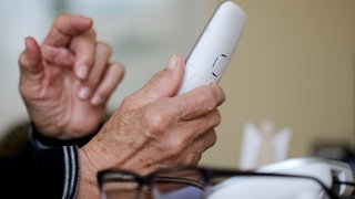 Masche Schockanruf: Eine ältere Dame nimmt in ihrer Wohnung ein Telefongespräch an (Symbolbild)