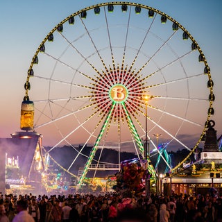 Blaue Stunde auf dem Frühlingsfest in Stuttgart: Am Osterwochenende 2025 startet auf dem Cannstatter Wasen wieder der Rummel.