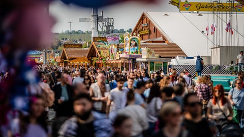 Besucher strömen bei schönem Wetter über das 85. Stuttgarter Frühlingsfest.