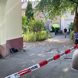 Ein Innenhof ist durch ein Band der Polizei abgesperrt.