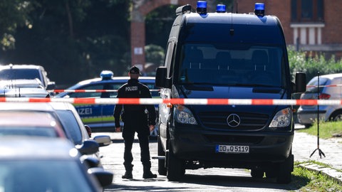Ein Kastenwagen der Polizei mit einem Ermittler und Polizeiabsperrband (Symbolbild). Ende August hat ein Bauhof-Mitarbeiter in Bonladen-Filderstadt eine Leiche gefunden. Die konnte mittlerweile identifiziert werden.